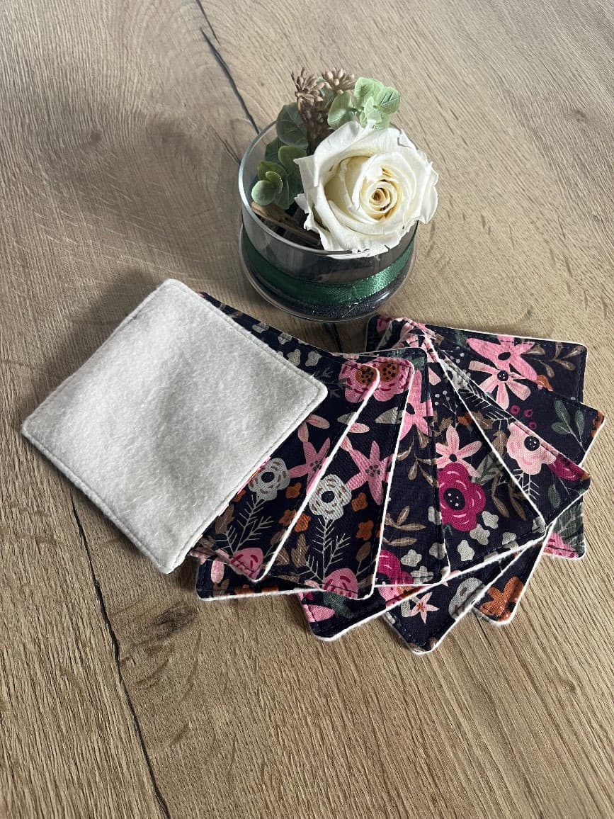 Lot de lingettes lavables à motif floral foncé et face en molleton blanc disposées en éventail.