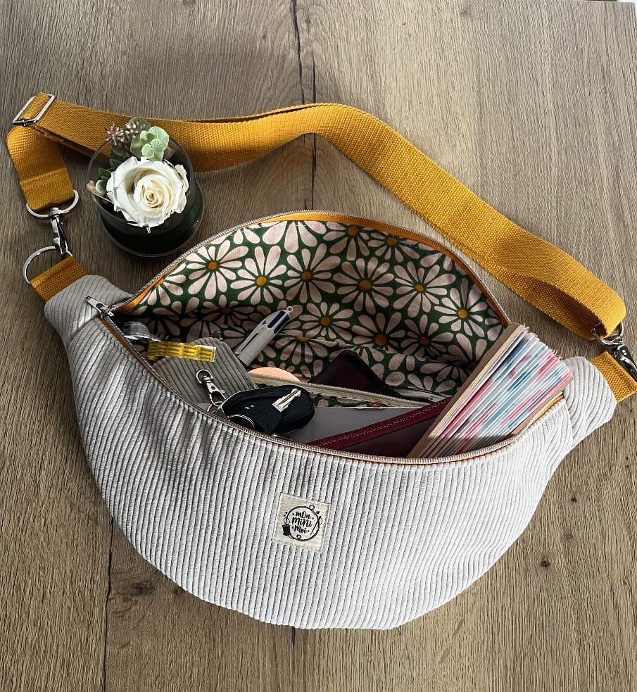Vue intérieure du sac banane ouvert rempli d'effets personnels, montrant la doublure à fleurs.